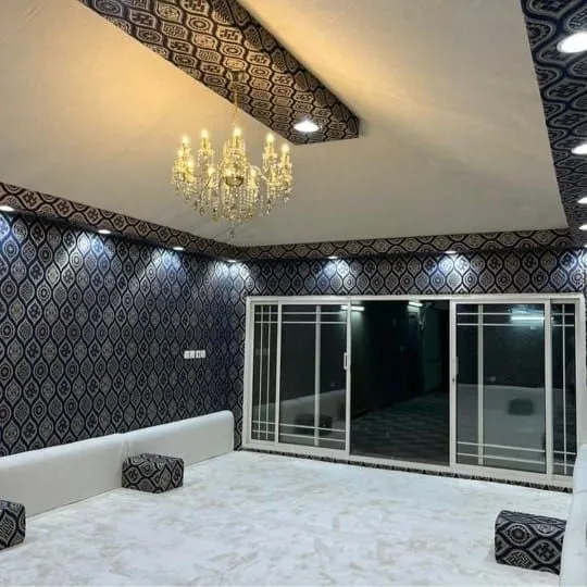 مجلس بتصميم داخلي مع جلسة فاتحة وأبواب زجاجية وثريا
